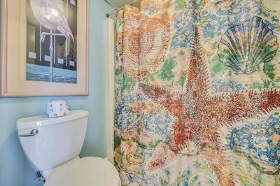 a bathroom with a shower curtain and a toilet at Aquavista Condominiums #206-W by Book That Condo in Panama City Beach