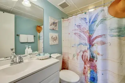 a bathroom with a shower curtain with a toilet and a sink at Aquavista Condominiums #206-W by Book That Condo in Panama City Beach