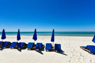 a group of chairs and umbrellas on a beach at Splash Beach Resort #1503-E by Book That Condo in Panama City Beach