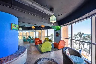 a living room with colorful chairs and a large window at Splash Beach Resort #1503-E by Book That Condo in Panama City Beach