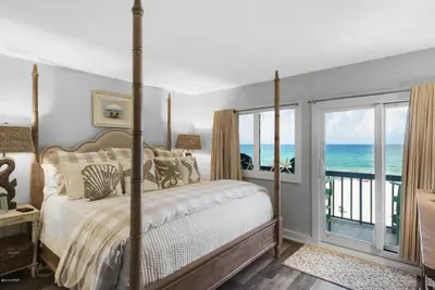 a bedroom with a bed and a view of the ocean at Pinnacle Port #115A by Book That Condo in Panama City Beach