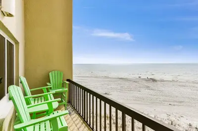two green chairs on a balcony overlooking the beach at Pinnacle Port #115A by Book That Condo in Panama City Beach