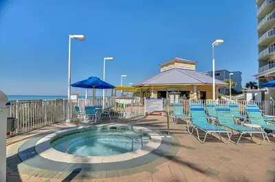 a patio with chairs and a pool and a building at Boardwalk Beach Resort #604 by Book That Condo in Panama City Beach