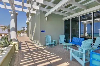 a patio with blue chairs and tables on a building at Boardwalk Beach Resort #604 by Book That Condo in Panama City Beach