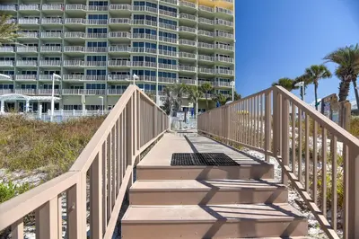 a staircase leading to a beach with a large building at Boardwalk Beach Resort #604 by Book That Condo in Panama City Beach