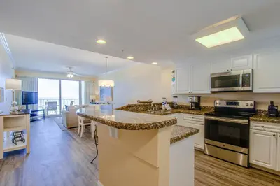 a kitchen with white cabinets and a counter top at Boardwalk Beach Resort #604 by Book That Condo in Panama City Beach
