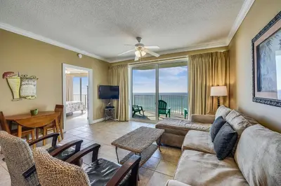 a living room with a couch and a table and chairs at Boardwalk Beach Resort #803 by Book That Condo in Panama City Beach