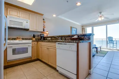 a kitchen with white appliances and a large window at Boardwalk Beach Resort #806 by Book That Condo in Panama City Beach