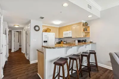 a kitchen with a counter and bar stools at Boardwalk Beach Resort #806 by Book That Condo in Panama City Beach