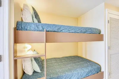 two bunk beds in a room with a bed at Boardwalk Beach Resort #1605 by Book That Condo in Panama City Beach