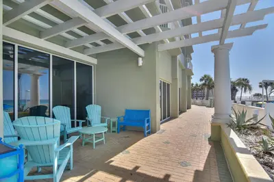 a patio with blue chairs and tables on a building at Boardwalk Beach Resort #1605 by Book That Condo in Panama City Beach