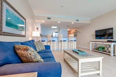 a living room with a blue couch and a table at Boardwalk Beach Resort #1703 by Book That Condo in Panama City Beach