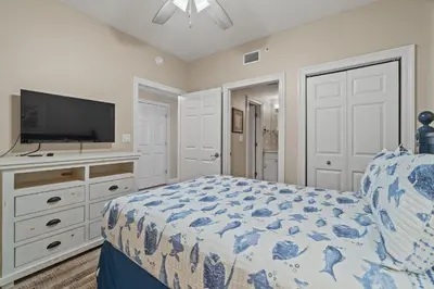 a bedroom with a bed and a flat screen tv at Boardwalk Beach Resort #1703 by Book That Condo in Panama City Beach