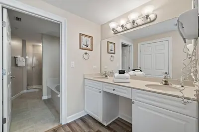 a white bathroom with a sink and a mirror at Boardwalk Beach Resort #1703 by Book That Condo in Panama City Beach