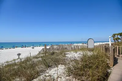 a sandy beach with a fence and the ocean at Boardwalk Beach Resort #1802 by Book That Condo in Panama City Beach