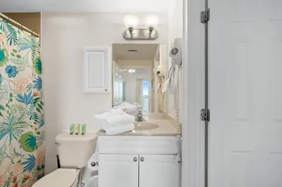 a bathroom with a sink and a toilet and a mirror at Boardwalk Beach Resort #1909 by Book That Condo in Panama City Beach