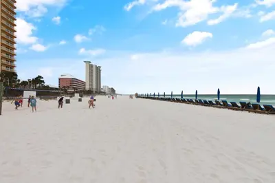 a group of people walking on the beach at Calypso Resort and Towers #602-E by Book That Condo in Panama City Beach