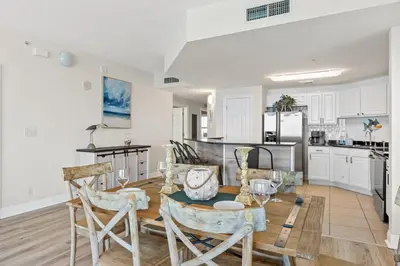 a kitchen with white cabinets and a table and chairs at Calypso Resort and Towers #801-W by Book That Condo in Panama City Beach