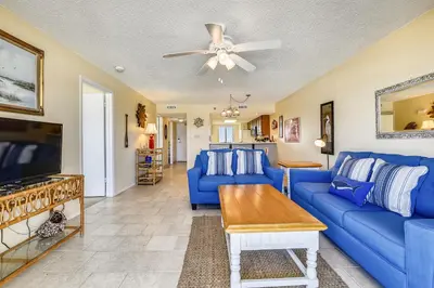 a living room with blue couches and a tv at Commodore Resort #703 by Book That Condo in Panama City Beach