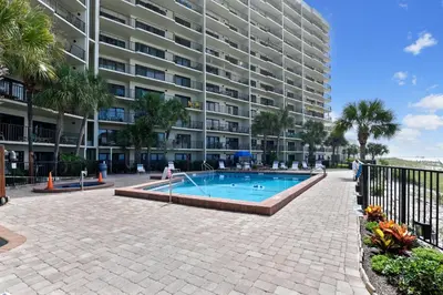 a swimming pool in front of a large building at Commodore Resort #703 by Book That Condo in Panama City Beach