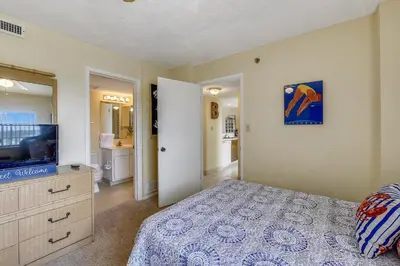 a bedroom with a bed and a flat screen tv at Commodore Resort #704 by Book That Condo in Panama City Beach