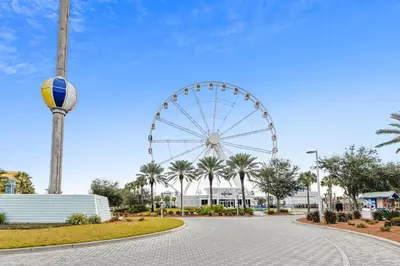 a ferris wheel in a park with palm trees at Commodore Resort #704 by Book That Condo in Panama City Beach