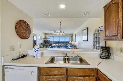 a kitchen with a sink and a view of the ocean at Commodore Resort #704 by Book That Condo in Panama City Beach