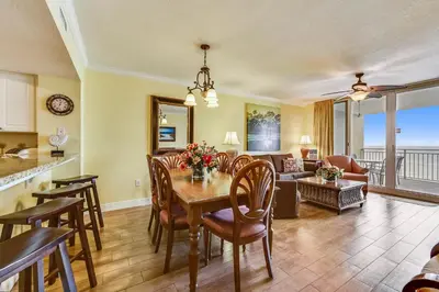a dining room and living room with a table and chairs at Emerald Beach #636 by Book That Condo in Panama City Beach