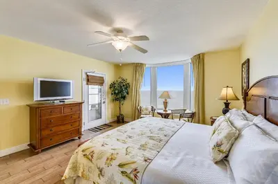 a bedroom with a large bed and a television at Emerald Beach #636 by Book That Condo in Panama City Beach