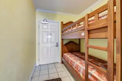 a bedroom with two bunk beds and a door at Emerald Beach #636 by Book That Condo in Panama City Beach