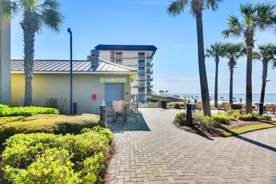 a building with palm trees next to a beach at Grand Panama Beach Resort #406-1 by Book That Condo in Panama City Beach