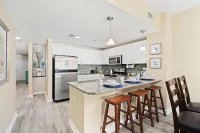 a kitchen with a large island with bar stools at Grand Panama Beach Resort #1707-1 by Book That Condo in Panama City Beach