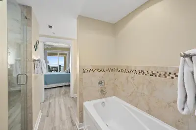 a white bathroom with a tub and a shower at Grand Panama Beach Resort #1707-1 by Book That Condo in Panama City Beach