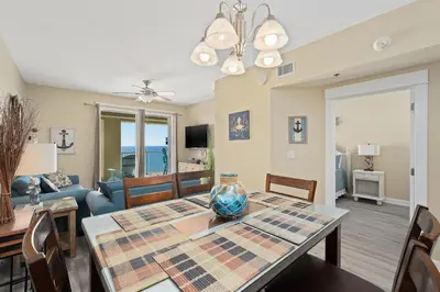a dining room and living room with a table and chairs at Grand Panama Beach Resort #1707-1 by Book That Condo in Panama City Beach
