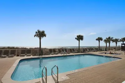 a swimming pool with palm trees in a resort at Ocean Villa Condos #801 by Book That Condo in Panama City Beach