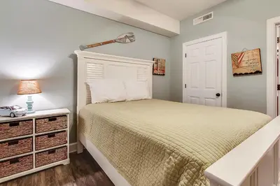a small bedroom with a bed and a lamp at Ocean Villa Condos #801 by Book That Condo in Panama City Beach