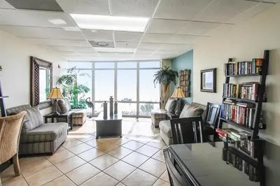 a living room with couches and chairs and a large window at Ocean Villa Condos #801 by Book That Condo in Panama City Beach