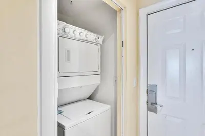 a small white kitchen with a washer and dryer at Ocean Villa Condos #1801 by Book That Condo in Panama City Beach