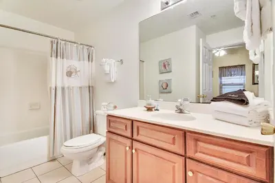 a bathroom with a sink and a toilet and a mirror at Ocean Villa Condos #1801 by Book That Condo in Panama City Beach