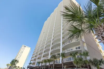 a tall building with palm trees in front of it at Ocean Villa Condos #1801 by Book That Condo in Panama City Beach