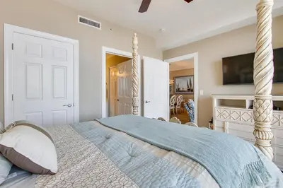 a bedroom with a bed and a tv on a wall at Twin Palms Resort #404 by Book That Condo in Panama City Beach