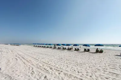 a line of umbrellas and chairs on a beach at Twin Palms Resort #404 by Book That Condo in Panama City Beach