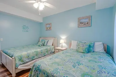 a bedroom with two beds and a ceiling fan at Twin Palms Resort #1605 by Book That Condo in Panama City Beach