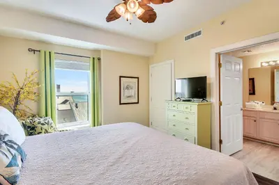 a bedroom with a bed and a tv and a window at Twin Palms Resort #1905 by Book That Condo in Panama City Beach