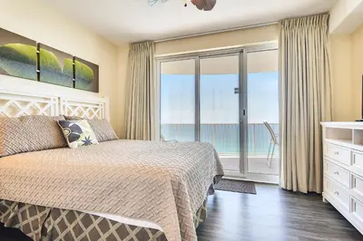a bedroom with a bed and a view of the ocean at Twin Palms Resort #1905 by Book That Condo in Panama City Beach