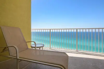 a chair on a balcony with a view of the ocean at Twin Palms Resort #1905 by Book That Condo in Panama City Beach