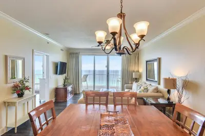 a dining room and living room with a table and chairs at Twin Palms Resort #1905 by Book That Condo in Panama City Beach