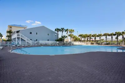 an empty swimming pool with a building and palm trees at Tidewater Beach Resort #508 by Book That Condo in Panama City Beach