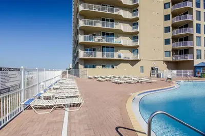 a swimming pool with lounge chairs and a building at Tidewater Beach Resort #508 by Book That Condo in Panama City Beach