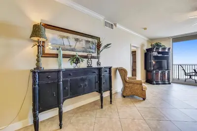 a living room with a black dresser and a chair at Tidewater Beach Resort #508 by Book That Condo in Panama City Beach